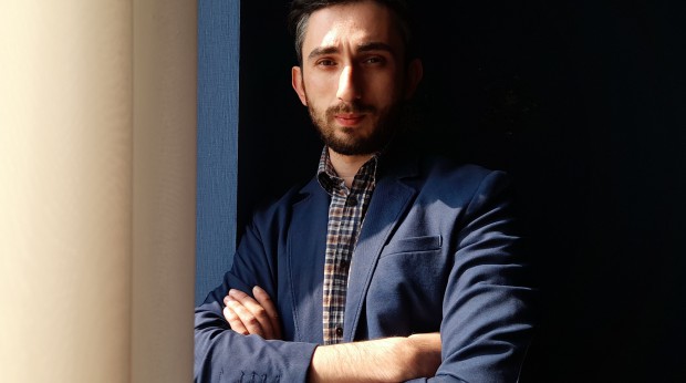 A young man leaning against a wall