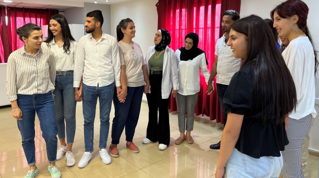 Young women and men standing next to each other during a workshop