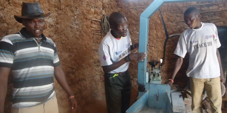 Achia (middle) during a learning visit for “Kaabong peace ambassadors” in Turkana - Kenya admiring a grinding project by youth in Turkana