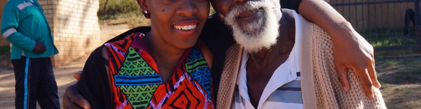 A young woman and an older man standing next to closely next to each other