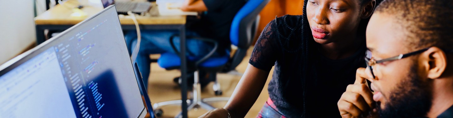 young people sitting in front of a computer