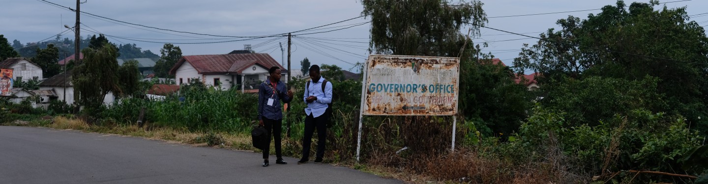 Two people walking on a street in Buea