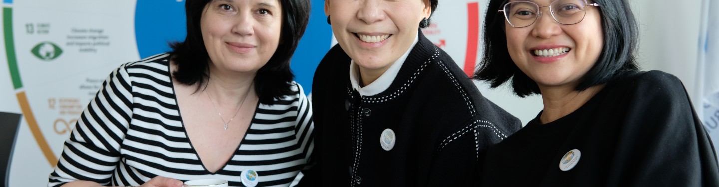 Photo of three GPPAC members sitting in front of an SDG wheel