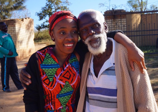 A young woman and an older man standing next to closely next to each other