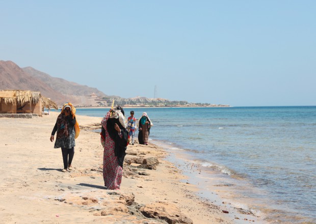 women walking along a beach in the middle east