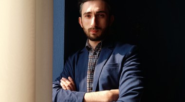 A young man leaning against a wall