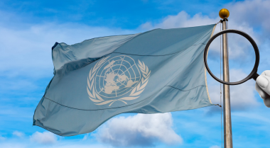 Magnifying glass in front of UN flag