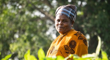 Woman with a smile on her face standing on the fields