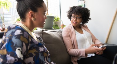 Two business women sitting on a couch