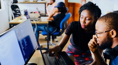 young people sitting in front of a computer