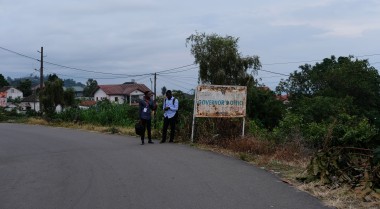 Two people walking on a street in Buea
